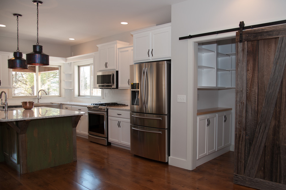 Exempel på ett mellanstort klassiskt kök, med en rustik diskho, luckor med upphöjd panel, skåp i rostfritt stål, kaklad bänkskiva, vitt stänkskydd, stänkskydd i tunnelbanekakel, rostfria vitvaror, mellanmörkt trägolv och en köksö