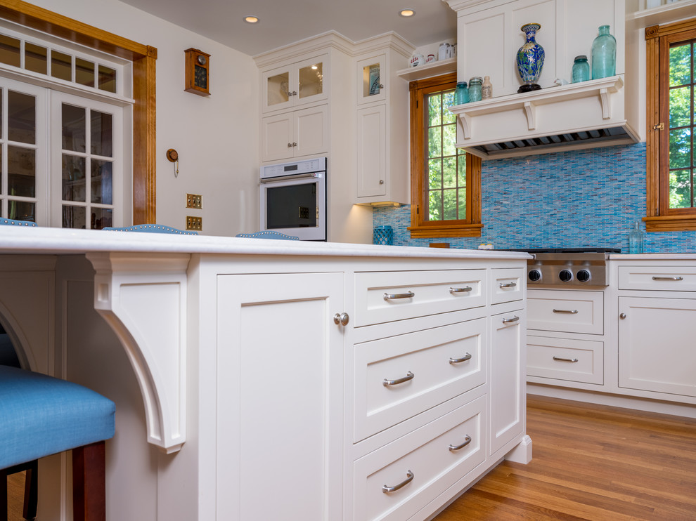 Esempio di una grande cucina chic con lavello sottopiano, ante lisce, ante bianche, paraspruzzi blu, paraspruzzi con piastrelle di vetro, elettrodomestici bianchi, parquet chiaro e pavimento blu
