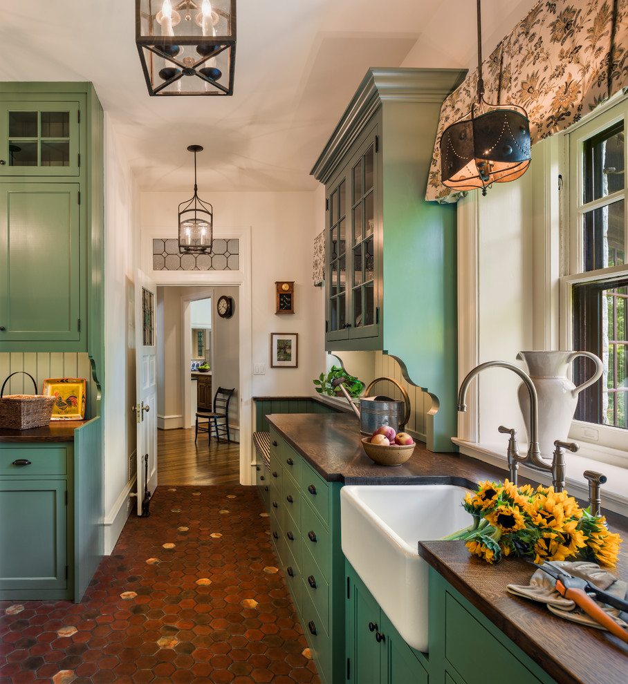 フィラデルフィアにあるトラディショナルスタイルのおしゃれな独立型キッチン (エプロンフロントシンク、シェーカースタイル扉のキャビネット、緑のキャビネット、テラコッタタイルの床、赤い床、木材カウンター) の写真