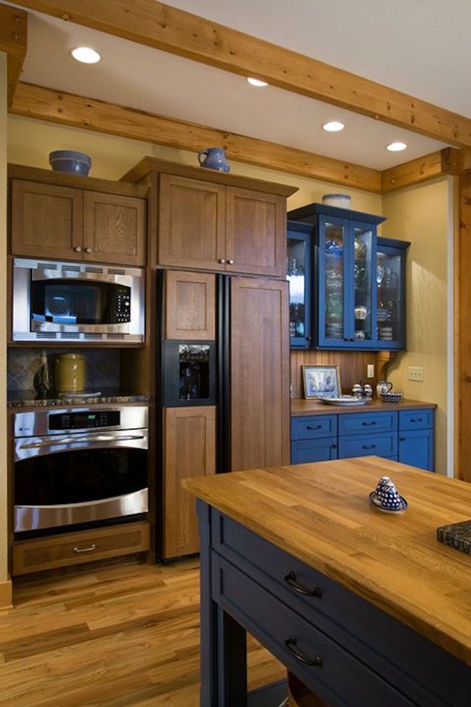 Mid-sized mountain style u-shaped light wood floor and beige floor open concept kitchen photo in Other with shaker cabinets, dark wood cabinets, granite countertops, beige backsplash, ceramic backsplash, stainless steel appliances, an island and an undermount sink
