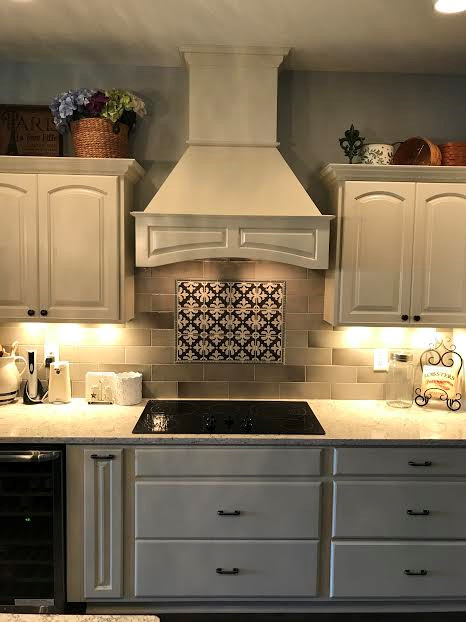 Bild på ett kök och matrum, med en undermonterad diskho, luckor med upphöjd panel, vita skåp, bänkskiva i kvarts, rostfria vitvaror och en köksö
