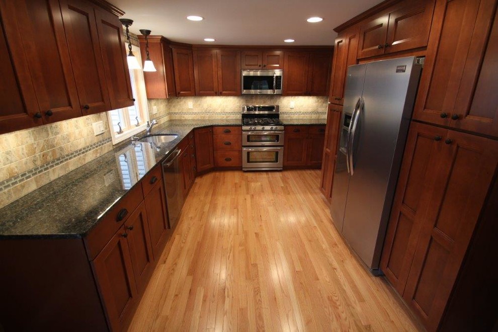 Eat-in kitchen - large contemporary u-shaped light wood floor eat-in kitchen idea in Boston with an undermount sink, shaker cabinets, medium tone wood cabinets, granite countertops, beige backsplash, stone tile backsplash, stainless steel appliances and a peninsula