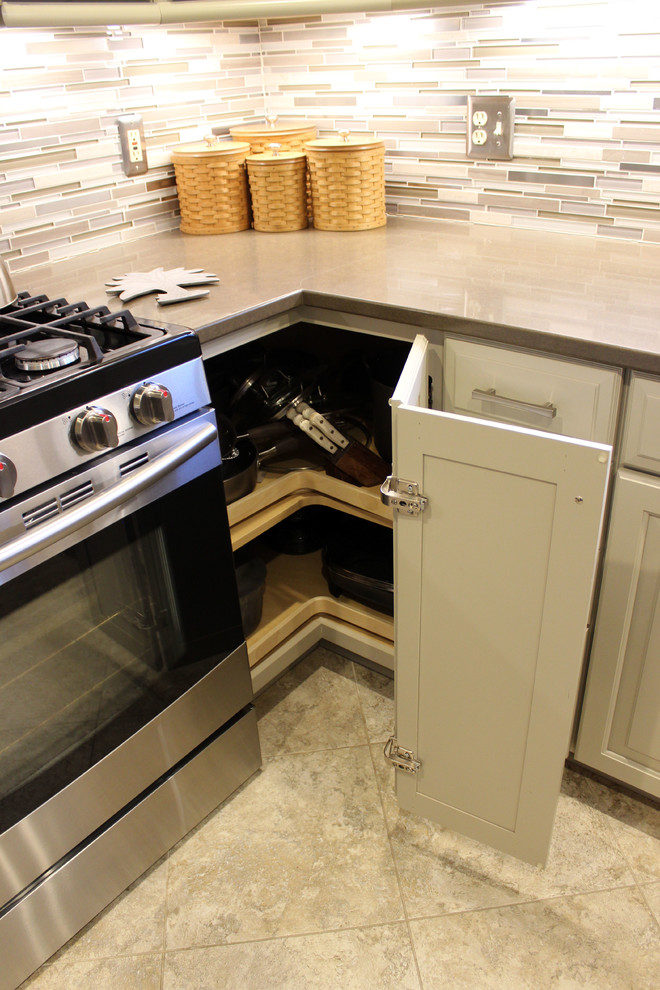 Inredning av ett klassiskt mellanstort brun brunt kök, med en undermonterad diskho, luckor med upphöjd panel, beige skåp, bänkskiva i kvarts, brunt stänkskydd, stänkskydd i glaskakel och en köksö
