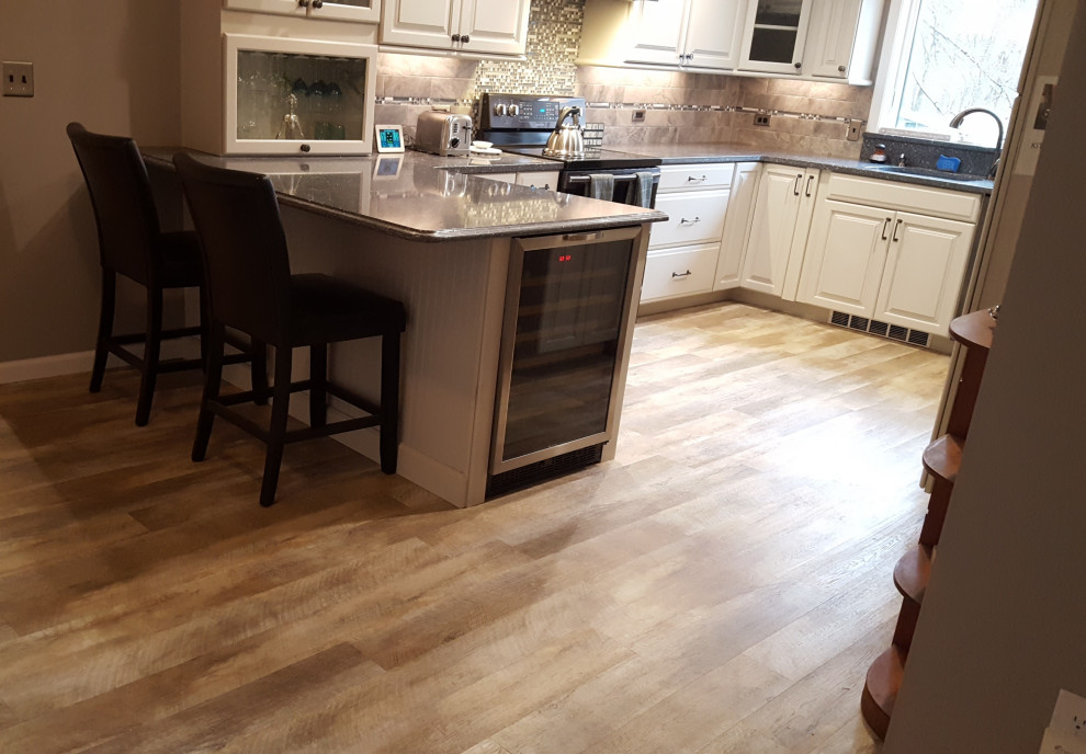 Inspiration for an u-shaped vinyl floor kitchen remodel in Bridgeport with an undermount sink, quartz countertops, gray backsplash, stainless steel appliances, a peninsula and gray countertops