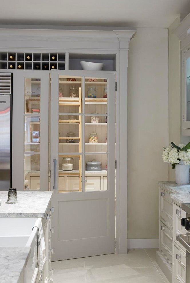 Klassisk inredning av ett mellanstort vit vitt kök, med luckor med infälld panel, vita skåp, marmorbänkskiva, vitt stänkskydd, stänkskydd i keramik, rostfria vitvaror, klinkergolv i keramik och en köksö
