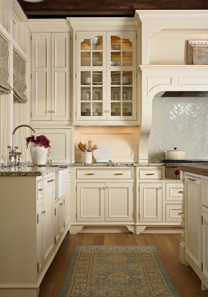 Modelo de cocina tradicional con armarios con rebordes decorativos y puertas de armario beige