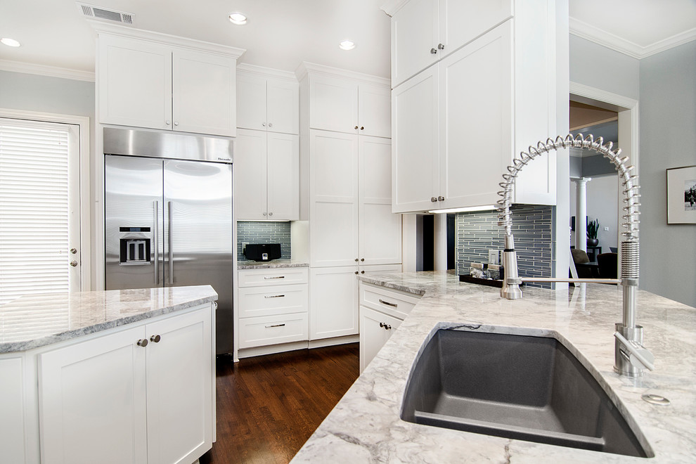 Mid-sized transitional galley medium tone wood floor eat-in kitchen photo in Dallas with an undermount sink, shaker cabinets, white cabinets, quartzite countertops, gray backsplash, glass tile backsplash and stainless steel appliances