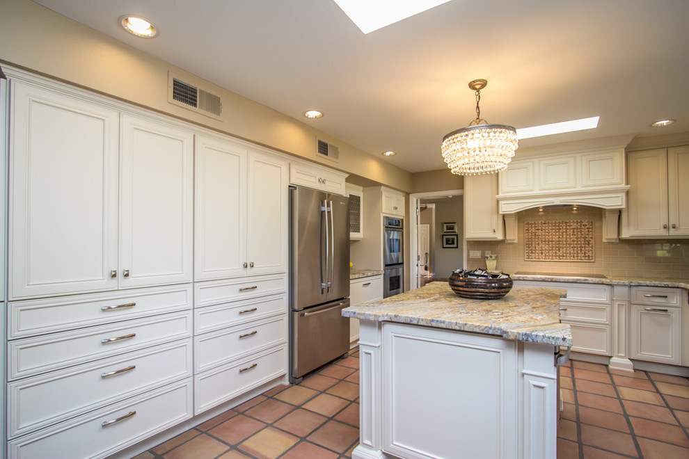 Large elegant u-shaped terra-cotta tile and brown floor enclosed kitchen photo in Phoenix with recessed-panel cabinets, white cabinets, granite countertops, beige backsplash, stainless steel appliances and an island