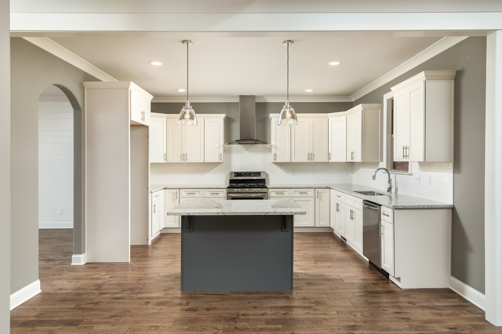 Open concept kitchen - mid-sized transitional l-shaped dark wood floor and brown floor open concept kitchen idea in Other with an undermount sink, shaker cabinets, white cabinets, granite countertops, white backsplash, subway tile backsplash, stainless steel appliances and an island