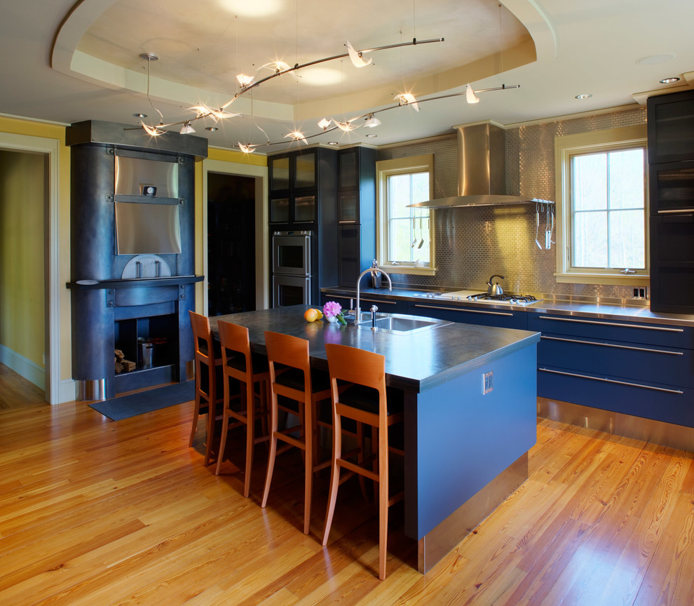Eat-in kitchen - mid-sized contemporary galley medium tone wood floor eat-in kitchen idea in Other with a double-bowl sink, flat-panel cabinets, black cabinets, stainless steel countertops, metallic backsplash, metal backsplash, stainless steel appliances and an island