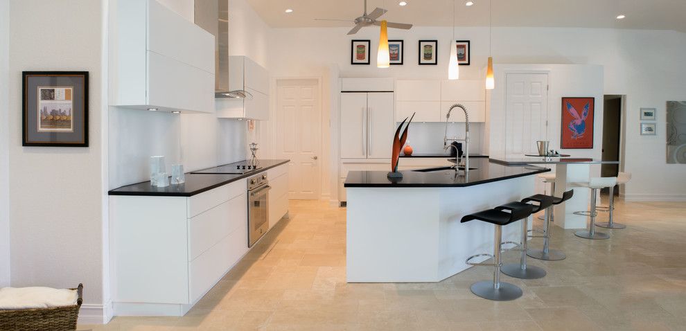 Inspiration for a medium sized contemporary l-shaped open plan kitchen in Miami with flat-panel cabinets, white cabinets, white splashback, glass sheet splashback, an island, a submerged sink, stainless steel appliances, ceramic flooring, quartz worktops and beige floors.