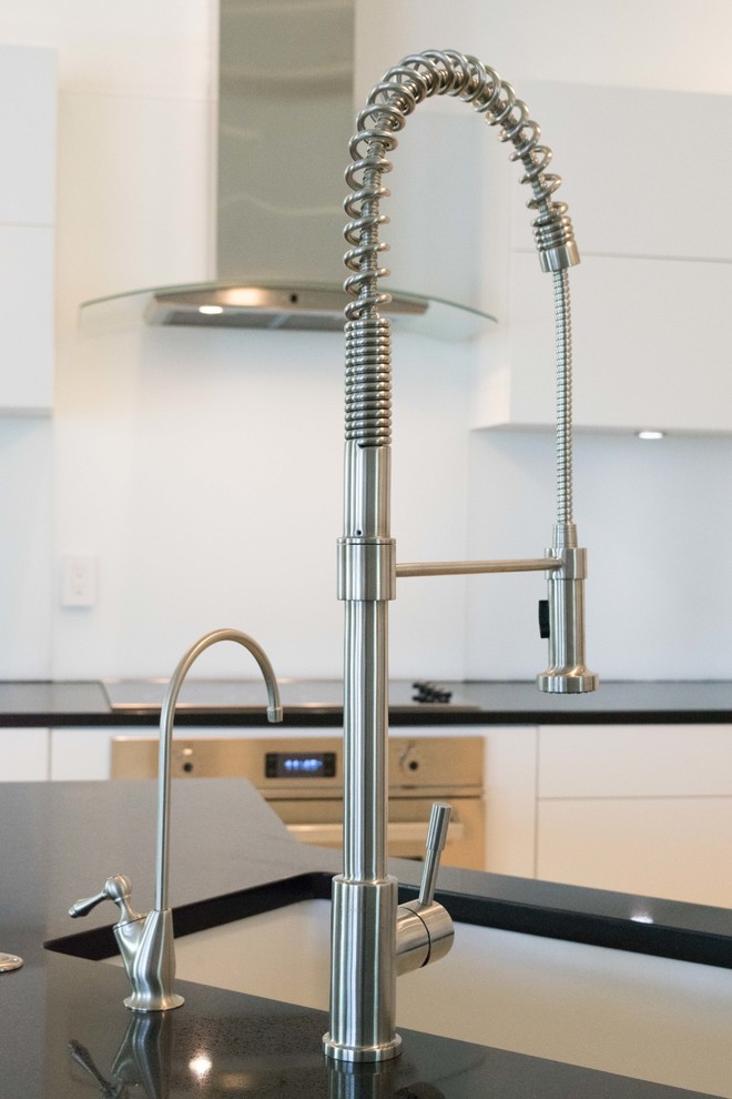 Immagine di una cucina design di medie dimensioni con lavello sottopiano, ante lisce, ante bianche, top in superficie solida, elettrodomestici in acciaio inossidabile e pavimento con piastrelle in ceramica