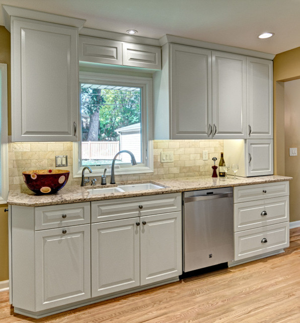 Inredning av ett modernt avskilt, mellanstort flerfärgad flerfärgat u-kök, med en dubbel diskho, luckor med upphöjd panel, vita skåp, granitbänkskiva, beige stänkskydd, stänkskydd i keramik, rostfria vitvaror, ljust trägolv, en halv köksö och beiget golv