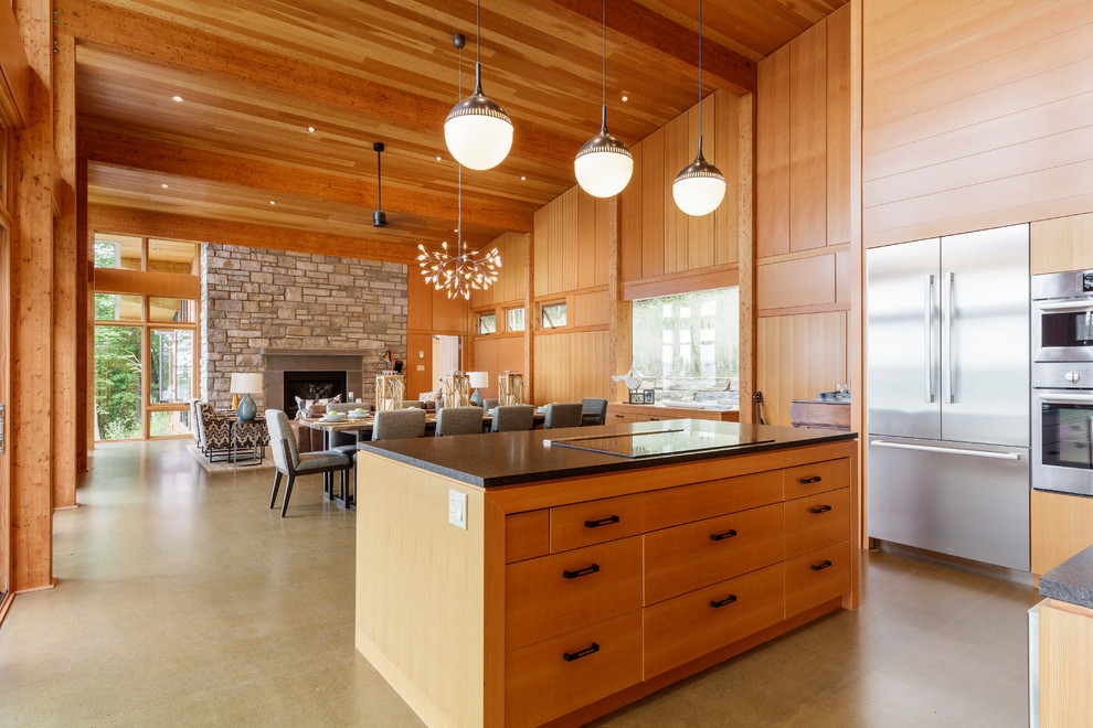 Foto på ett funkis kök med öppen planlösning, med en dubbel diskho, släta luckor, granitbänkskiva, stänkskydd i sten, rostfria vitvaror, betonggolv och en köksö