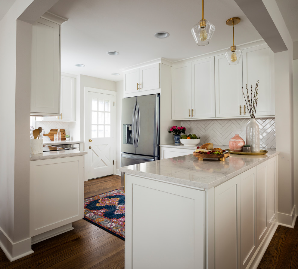 This is an example of a small traditional u-shaped kitchen in Seattle with shaker cabinets, white cabinets, engineered stone countertops, white splashback, ceramic splashback, stainless steel appliances, medium hardwood flooring, brown floors, white worktops and no island.