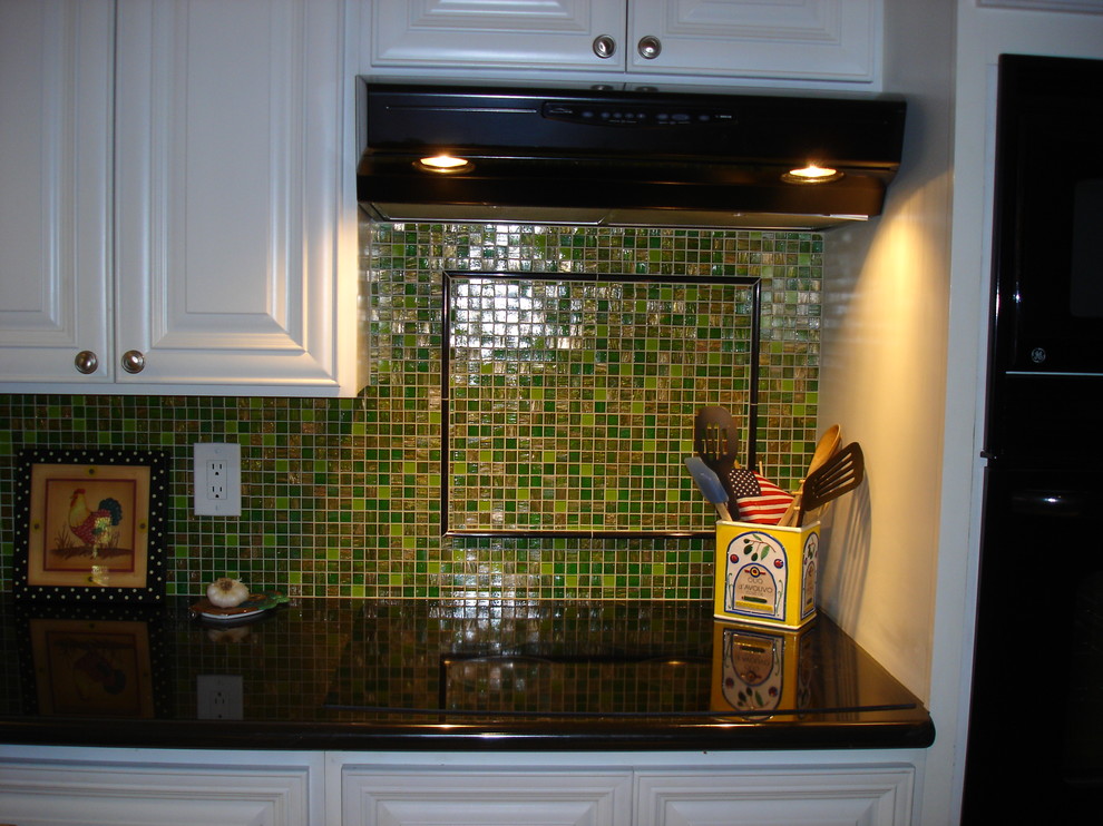 Foto på ett mellanstort vintage kök, med luckor med upphöjd panel, vita skåp, granitbänkskiva, grönt stänkskydd och stänkskydd i mosaik