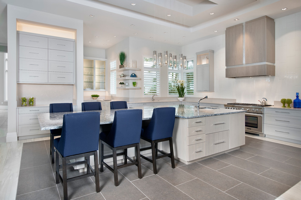 Photo of an expansive contemporary l-shaped kitchen/diner in Miami with a submerged sink, stainless steel appliances, an island, flat-panel cabinets, grey cabinets, granite worktops and white splashback.