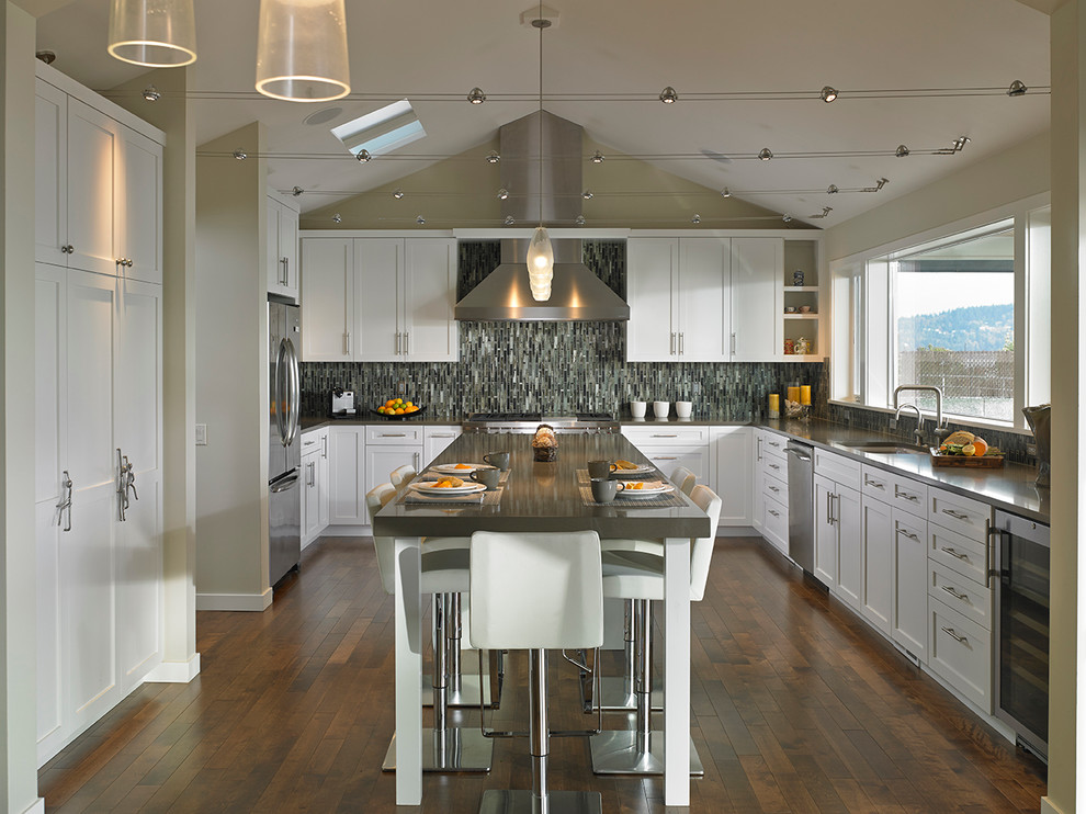 シアトルにある高級な広いモダンスタイルのおしゃれなキッチン (アンダーカウンターシンク、シェーカースタイル扉のキャビネット、白いキャビネット、マルチカラーのキッチンパネル、ボーダータイルのキッチンパネル、シルバーの調理設備、クッションフロア、茶色い床) の写真