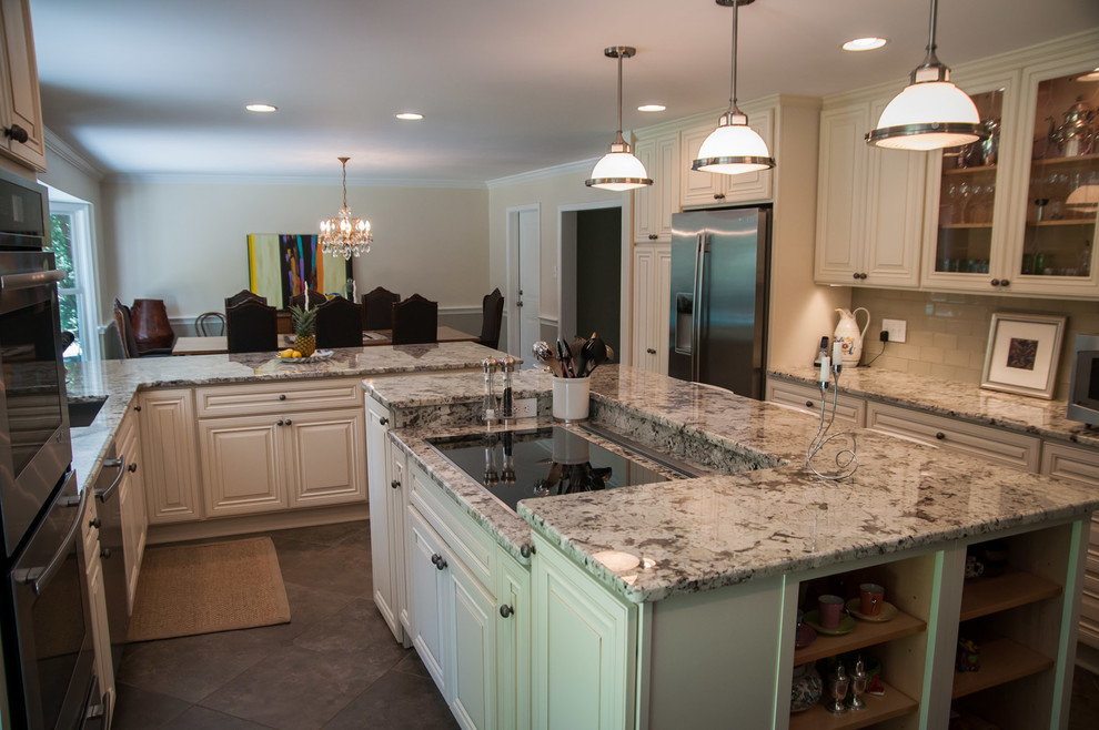 Elegant u-shaped eat-in kitchen photo in Philadelphia with an undermount sink, recessed-panel cabinets, white cabinets, granite countertops, green backsplash, glass tile backsplash and stainless steel appliances