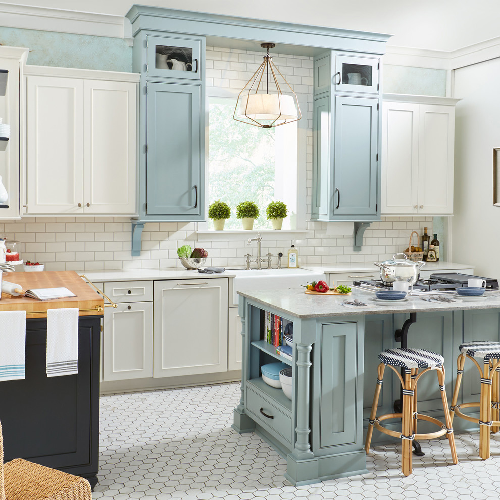 Bild på ett vintage grå grått l-kök, med en rustik diskho, luckor med profilerade fronter, blå skåp, vitt stänkskydd, stänkskydd i tunnelbanekakel, integrerade vitvaror, en köksö och vitt golv