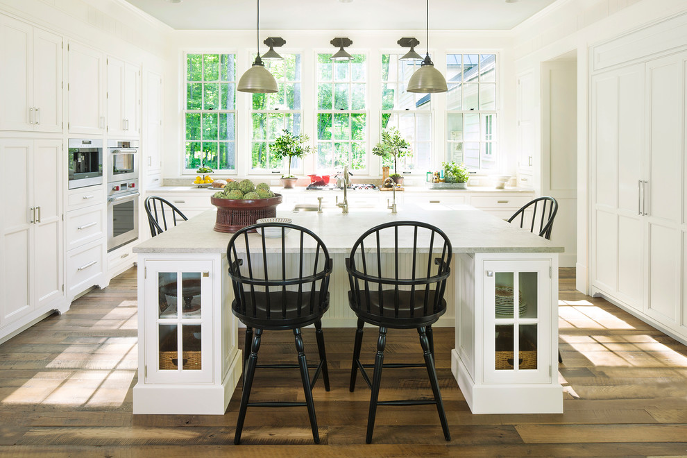 Landhaus Küche in U-Form mit Schrankfronten mit vertiefter Füllung, weißen Schränken, dunklem Holzboden, Kücheninsel und braunem Boden in Philadelphia