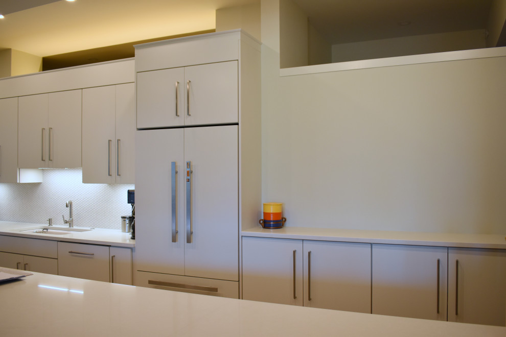 Large contemporary l-shaped open plan kitchen in Boston with flat-panel cabinets, white cabinets, engineered stone countertops, white splashback, mosaic tiled splashback, an island and yellow worktops.