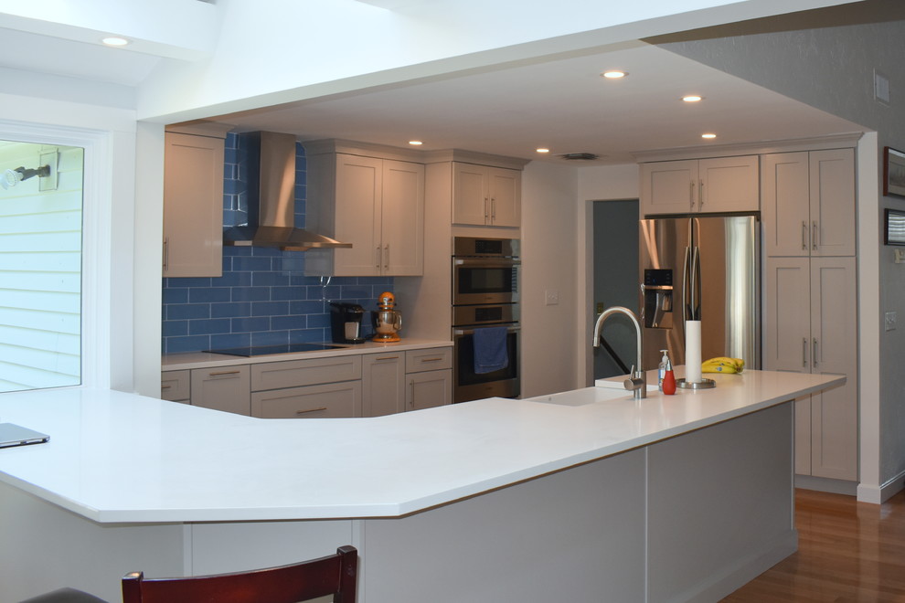 Exempel på ett mellanstort klassiskt vit vitt kök, med en rustik diskho, skåp i shakerstil, grå skåp, bänkskiva i kvarts, blått stänkskydd, stänkskydd i glaskakel, rostfria vitvaror, mellanmörkt trägolv, en halv köksö och beiget golv