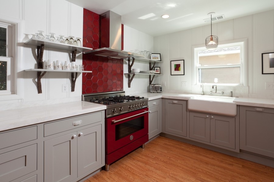Mid-sized trendy u-shaped medium tone wood floor eat-in kitchen photo in Sacramento with a farmhouse sink, shaker cabinets, gray cabinets, red backsplash, stainless steel appliances and no island