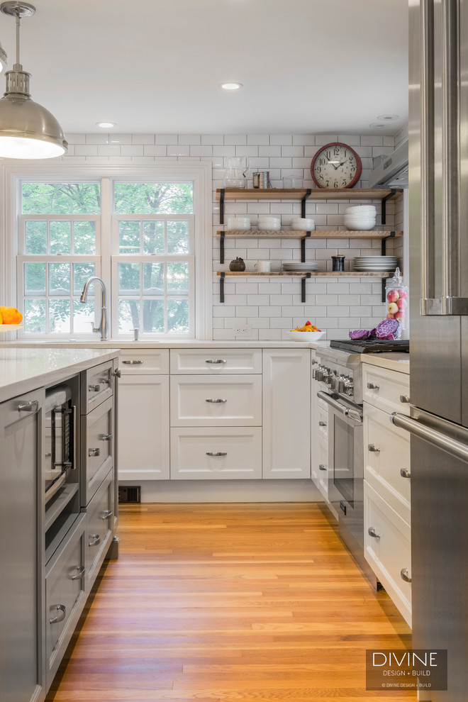 Foto på ett mellanstort eklektiskt kök, med en undermonterad diskho, skåp i shakerstil, vita skåp, bänkskiva i kvarts, vitt stänkskydd, stänkskydd i tunnelbanekakel, rostfria vitvaror, mellanmörkt trägolv, en köksö och brunt golv