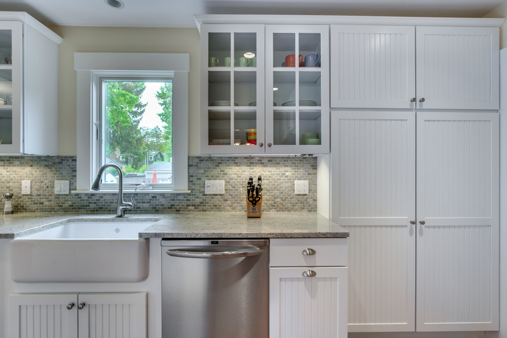 Inspiration for a mid-sized timeless l-shaped eat-in kitchen remodel in Boston with a farmhouse sink, louvered cabinets, white cabinets, granite countertops, multicolored backsplash, subway tile backsplash, stainless steel appliances and an island