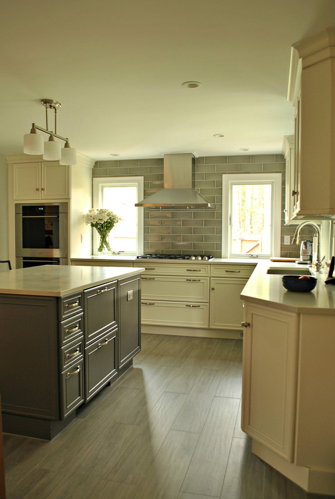 Exempel på ett mellanstort modernt kök, med en undermonterad diskho, luckor med infälld panel, vita skåp, bänkskiva i kvarts, grått stänkskydd, stänkskydd i glaskakel, rostfria vitvaror, klinkergolv i keramik och en köksö