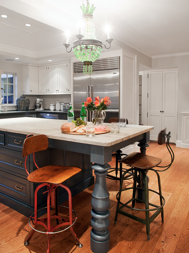 Inredning av ett klassiskt stort l-kök, med en undermonterad diskho, luckor med upphöjd panel, skåp i mörkt trä, marmorbänkskiva, rött stänkskydd, stänkskydd i tegel, rostfria vitvaror, mellanmörkt trägolv, en köksö och brunt golv