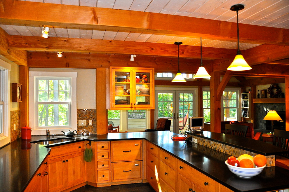 Cette image montre une grande cuisine américaine design en U et bois brun avec une péninsule, un placard avec porte à panneau encastré, un plan de travail en granite, un électroménager en acier inoxydable, un évier encastré et parquet clair.