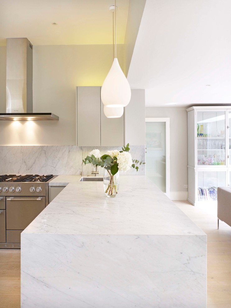 Design ideas for a contemporary kitchen in London with a single-bowl sink, flat-panel cabinets, marble worktops and light hardwood flooring.