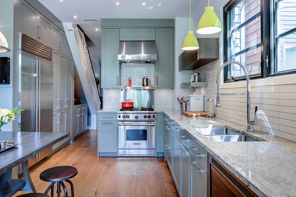 Example of a mid-sized ornate l-shaped eat-in kitchen design in Toronto with a double-bowl sink, green cabinets, granite countertops, white backsplash, porcelain backsplash, stainless steel appliances, shaker cabinets and no island