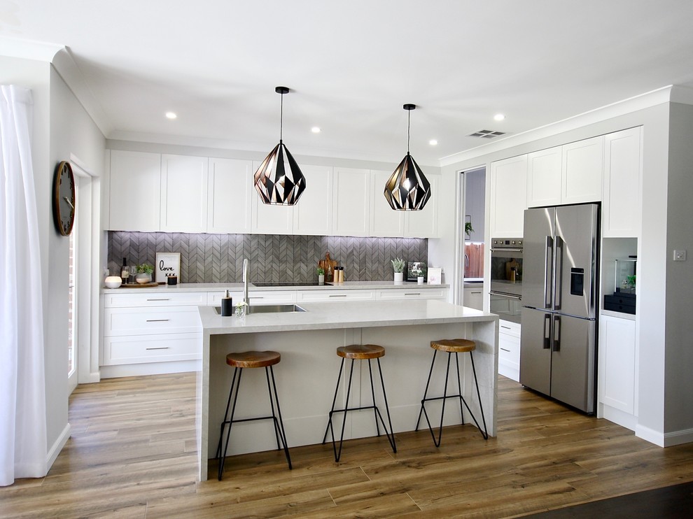 Idéer för ett stort modernt grå kök, med en nedsänkt diskho, skåp i shakerstil, vita skåp, bänkskiva i kvarts, grått stänkskydd, stänkskydd i keramik, rostfria vitvaror, mellanmörkt trägolv, en köksö och brunt golv