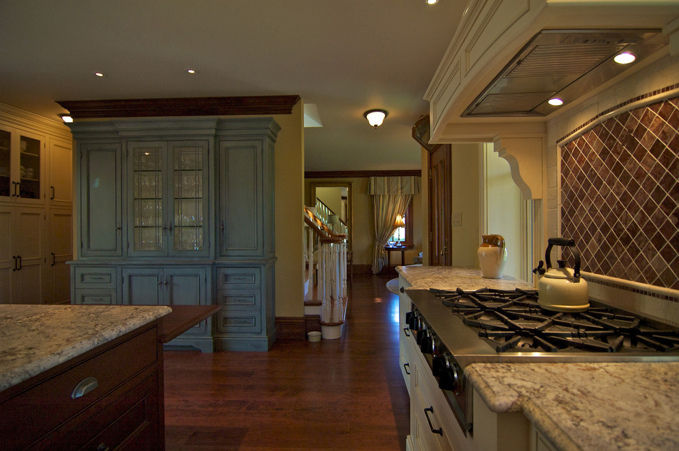 This is an example of a country l-shaped enclosed kitchen in Toronto with beaded cabinets, white cabinets, marble worktops, stainless steel appliances and an island.