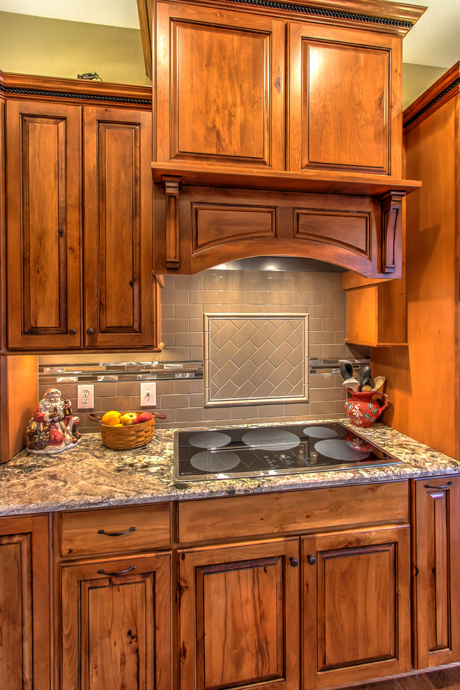 Rustic kitchen in Other with raised-panel cabinets, granite worktops, metro tiled splashback and an island.