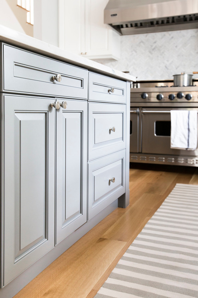 Ejemplo de cocina moderna con fregadero de un seno, encimera de acrílico, salpicadero de azulejos de piedra, electrodomésticos de acero inoxidable y suelo de madera clara