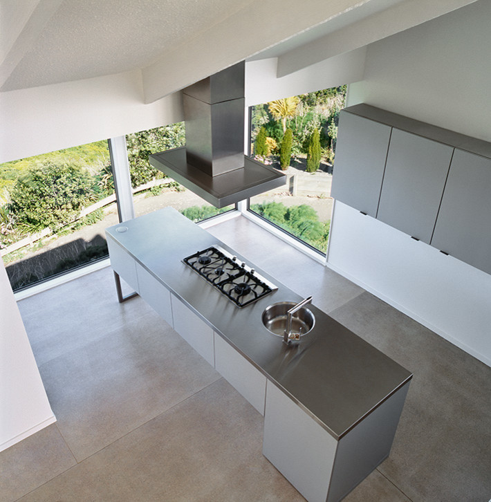 Esempio di una cucina design con lavello a vasca singola, ante grigie, top in acciaio inossidabile, elettrodomestici in acciaio inossidabile e pavimento in cemento