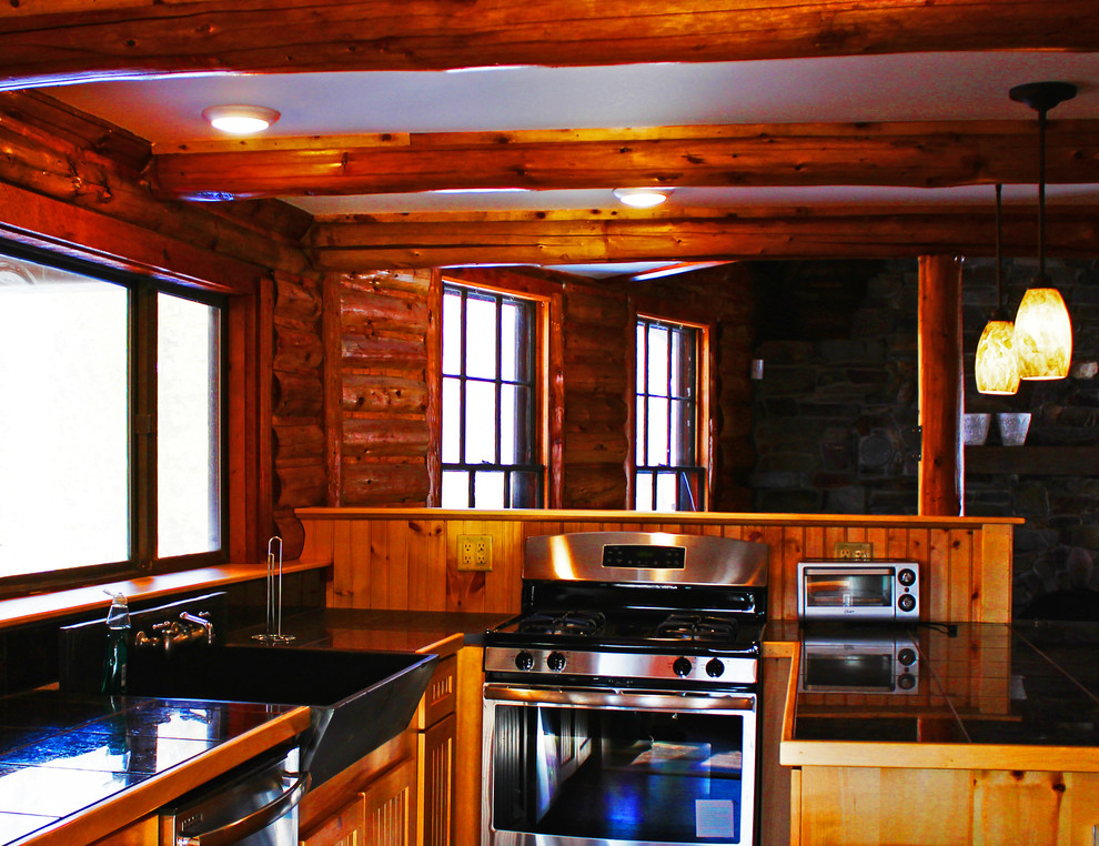 Mittelgroße Rustikale Küche in U-Form mit Landhausspüle, Arbeitsplatte aus Fliesen, Küchengeräten aus Edelstahl und hellem Holzboden in Sonstige