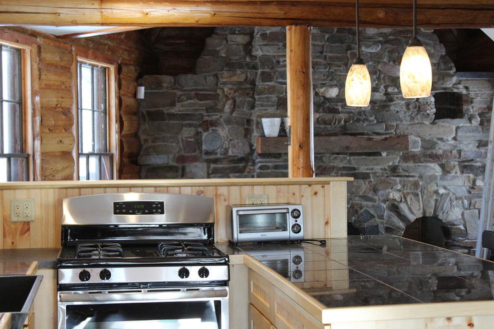 Foto på ett mellanstort rustikt u-kök, med en rustik diskho, kaklad bänkskiva, rostfria vitvaror och ljust trägolv