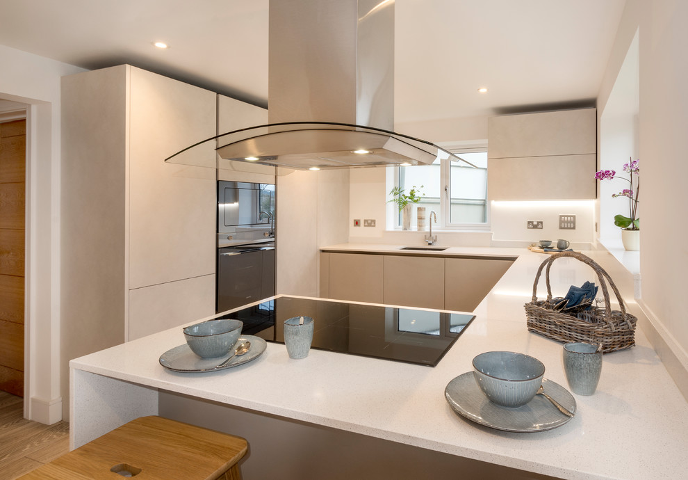 Medium sized modern kitchen/diner in Devon with a single-bowl sink, glass-front cabinets, blue cabinets, red splashback, stainless steel appliances, laminate floors, grey floors and white worktops.