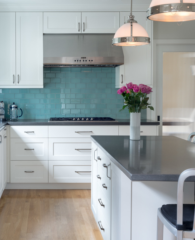 На фото: кухня в стиле неоклассика (современная классика) с синим фартуком, фартуком из стеклянной плитки и островом
