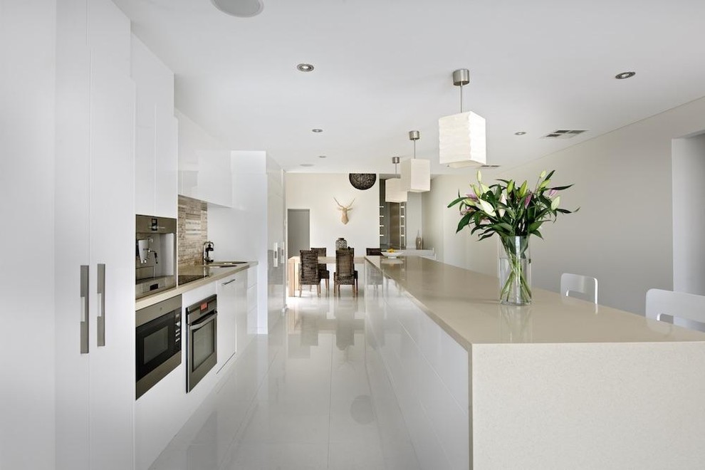 Offene Moderne Küche mit Doppelwaschbecken, weißen Schränken, Granit-Arbeitsplatte, Küchengeräten aus Edelstahl, Kücheninsel und weißem Boden in Perth