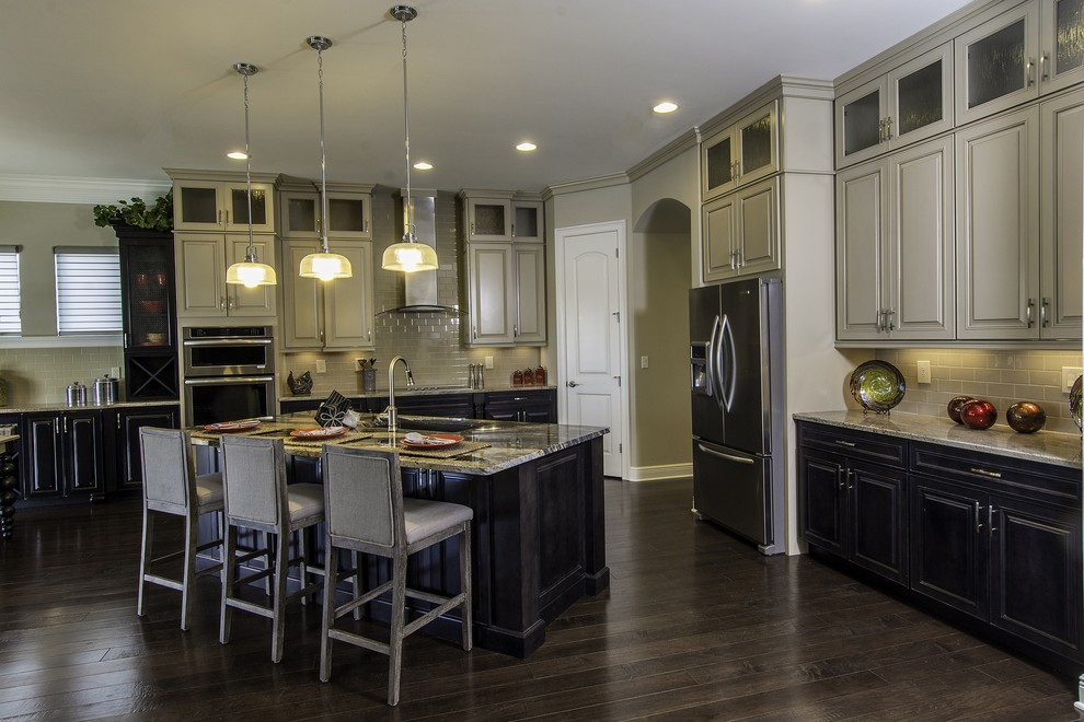 Example of a huge transitional l-shaped dark wood floor open concept kitchen design in Tampa with an undermount sink, raised-panel cabinets, beige cabinets, granite countertops, subway tile backsplash, stainless steel appliances, an island and beige backsplash