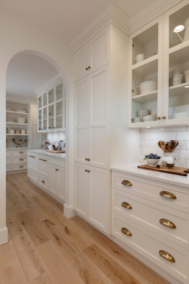 Large classic kitchen pantry in Vancouver with shaker cabinets, white cabinets, white splashback, ceramic splashback, integrated appliances, an island and white worktops.