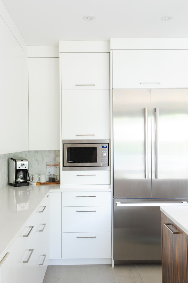 Idee per una cucina minimalista di medie dimensioni con lavello sottopiano, ante lisce, ante bianche, top in superficie solida, paraspruzzi grigio, paraspruzzi con piastrelle a mosaico e top bianco