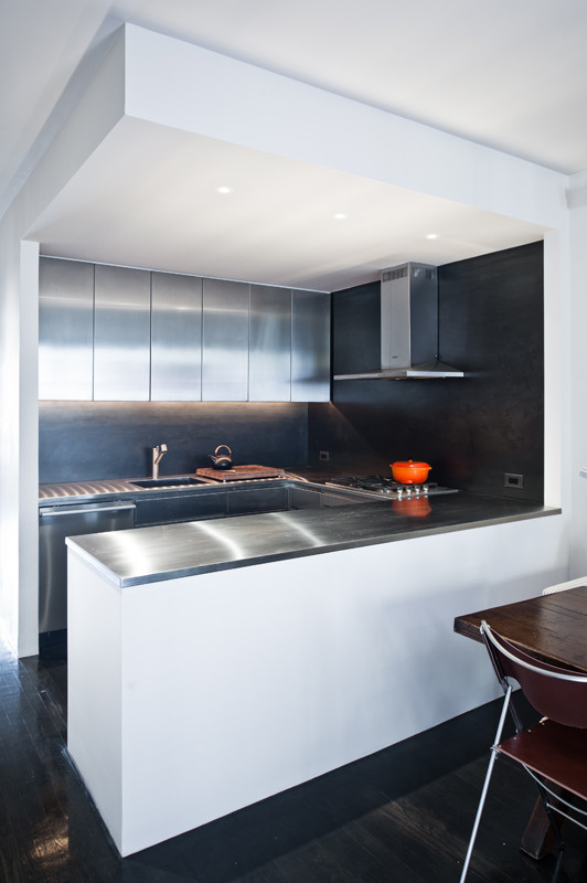 Example of a small trendy galley dark wood floor eat-in kitchen design in New York with flat-panel cabinets, a peninsula, stainless steel cabinets, stainless steel countertops, black backsplash, an undermount sink, stainless steel appliances and metal backsplash