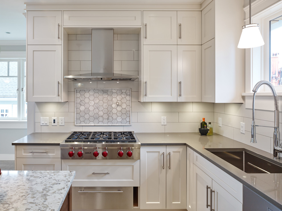 Design ideas for a medium sized classic l-shaped open plan kitchen in Vancouver with a submerged sink, shaker cabinets, engineered stone countertops, white splashback, porcelain splashback, stainless steel appliances, porcelain flooring, an island, white cabinets, grey floors and grey worktops.